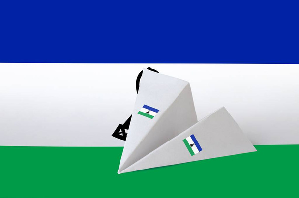 Lesotho zászló ábrázolt papír origami repülőgép. Keleti kézműves művészeti koncepció - Fotó, kép