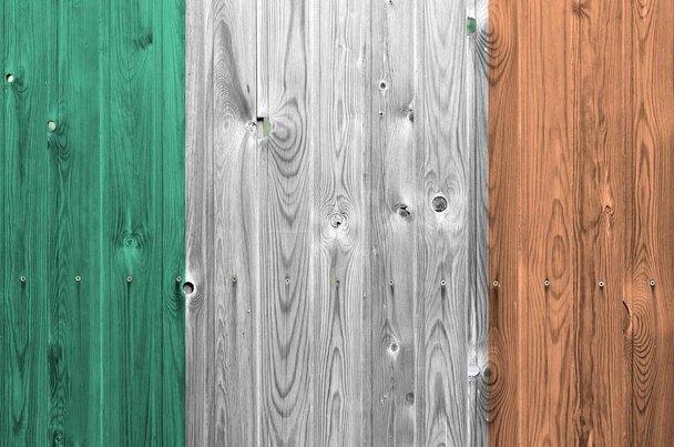 Irská vlajka vyobrazená v jasných barvách na staré dřevěné stěně zblízka. Texturovaný nápis na hrubém pozadí - Fotografie, Obrázek