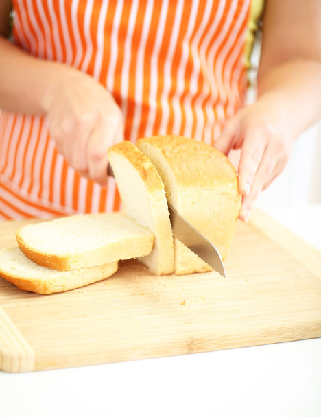 Woman slicing bread on chopping board, close up - Valokuva, kuva