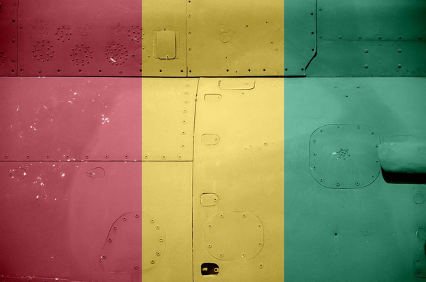 軍用装甲ヘリコプターの側面に描かれたギニアの旗が閉じます。陸軍航空機の概念的背景 - 写真・画像