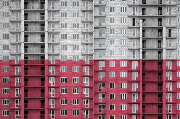 Bandera de Polonia representada en colores de pintura en un edificio residencial de varios pisos en construcción. Banner texturizado sobre fondo de pared de ladrillo grande
 - Foto, Imagen