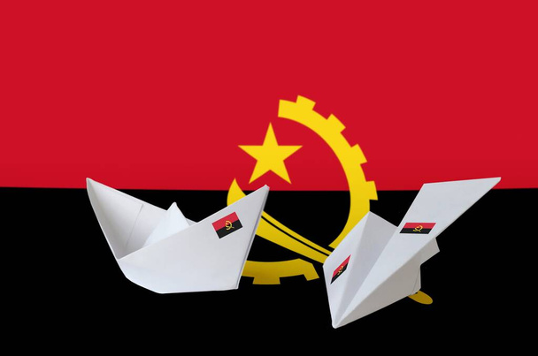 Angola flag depicted on paper origami airplane and boat. Oriental handmade arts concept - Photo, Image