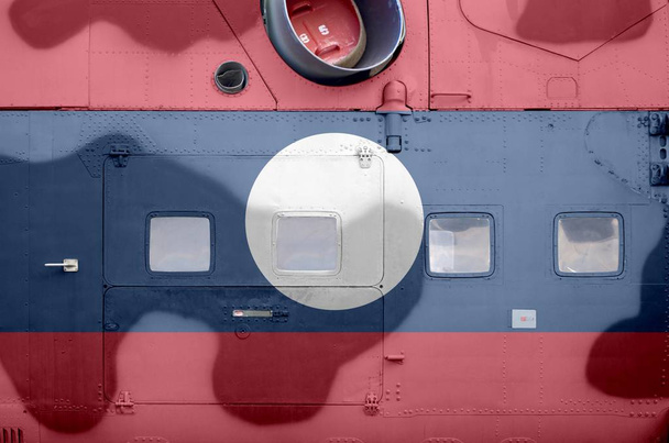 A laoszi zászló a katonai páncélozott helikopter oldalsó részén látható, közelről. Hadsereg erők repülőgép koncepcionális háttér - Fotó, kép