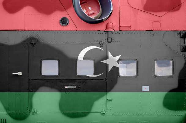 Líbia zászlaját a katonai páncélozott helikopter oldalsó részén, közelről ábrázolták. Hadsereg erők repülőgép koncepcionális háttér - Fotó, kép