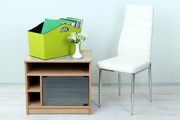 雑誌や部屋のベッドサイド テーブルの上の緑色のボックス内のフォルダー - 写真・画像