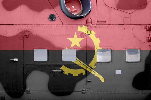 Drapeau de l'Angola représenté de près sur une partie latérale d'un hélicoptère blindé militaire. Forces armées avions arrière-plan conceptuel
 - Photo, image