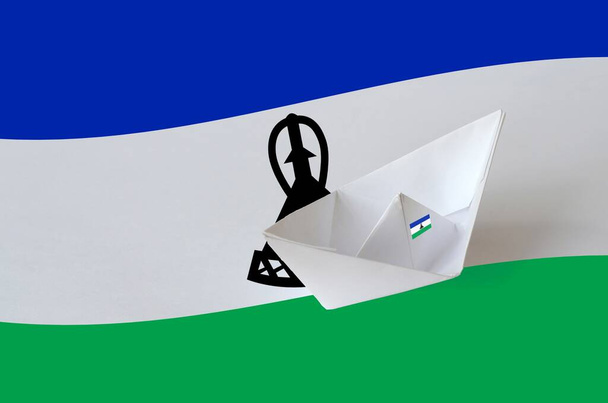 Lesotho zászló ábrázolt papír origami hajó közelkép. Keleti kézműves művészeti koncepció - Fotó, kép