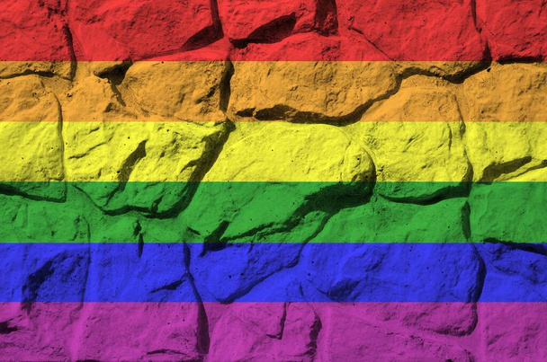 Флаг ЛГБТ-сообщества изображен в красках на старой каменной стене крупным планом. Текстурированный баннер на фоне скальной стены
 - Фото, изображение