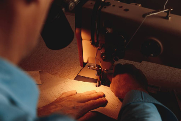 A closeup shot of a person doing handwork with a sewing machine - Fotó, kép