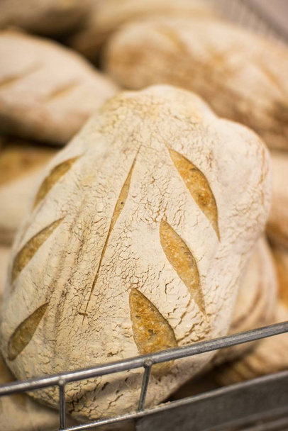 Vertical shot of freshly baked delicious sourdough bread with nice decoration - Foto, immagini