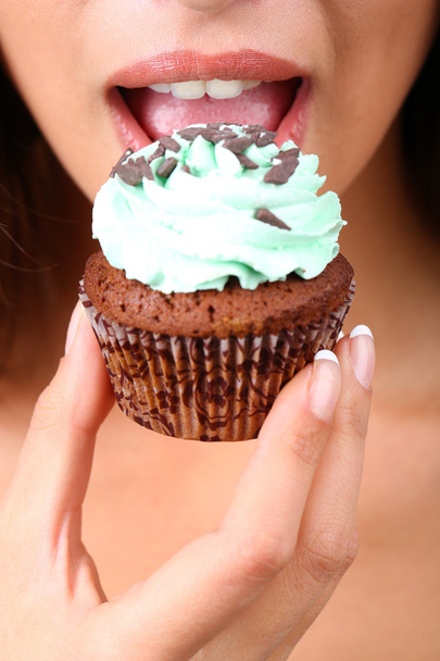 Closeup of woman eating chocolate cupcake - Foto, Imagem