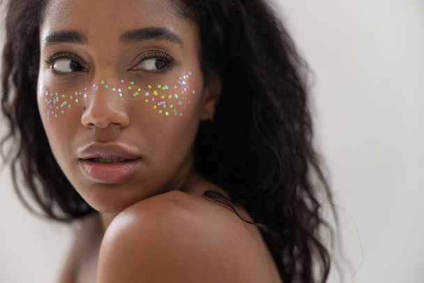 süße Afroamerikanerin mit verblüffendem Make-up posiert für die Kamera - Foto, Bild