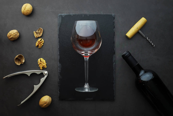 Ποτήρι κρασιού και μαύρο μπουκάλι κρασί. Τυρί με κέλυφος και ντομάτες για s - Φωτογραφία, εικόνα