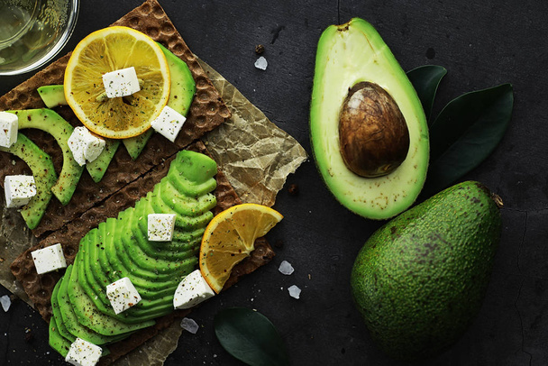 Avocado cooking recipes. Ripe green avocado on a wooden cutting  - 写真・画像
