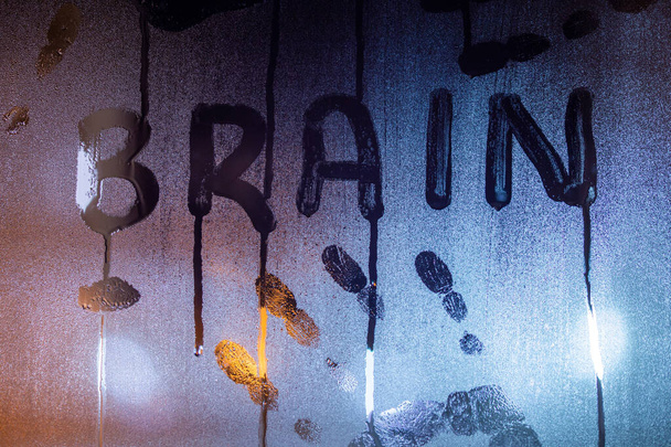 la palabra cerebro escrita en vidrio de ventana húmedo de noche con huellas de palma primer plano con fondo borroso
 - Foto, imagen
