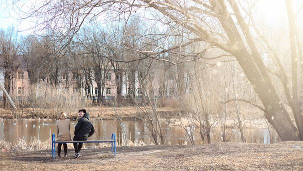 Ένα ζευγάρι νέων ανθρώπων συναντήθηκε στο πάρκο. Λάτρεις της κάθονται σε μια  - Φωτογραφία, εικόνα