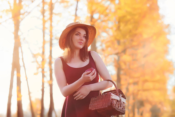 A girl in a hat on a walk in the park. A girl with a basket walk - Fotoğraf, Görsel