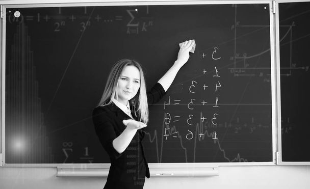 Achtergrond met wiskundige symbolen en leraar op de basisschool - Foto, afbeelding