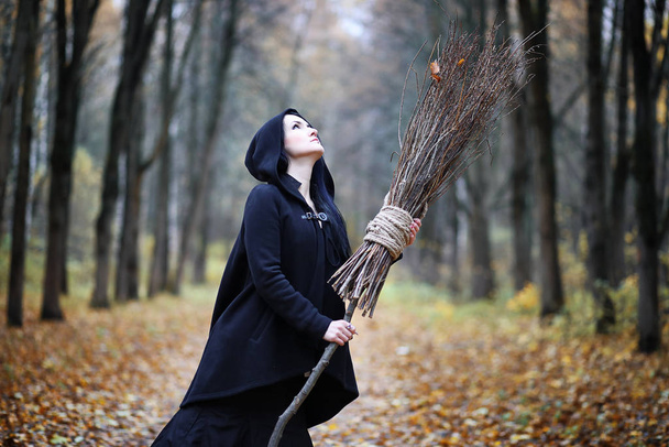 Una mujer con un traje de bruja en un bosque
 - Foto, imagen