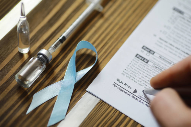 A man signs a medical document. Medical equipment on the table.  - Photo, image