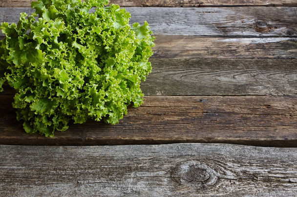 Tête de salade fraîche verte avec racine sur une vieille surface rugueuse en bois, concept de saine alimentation, accent sélectif
 - Photo, image