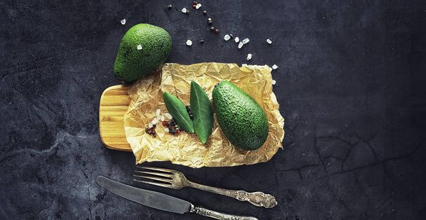 Avokado yemek tarifleri. Olgun yeşil avokado ahşap bir kesim üzerinde  - Fotoğraf, Görsel