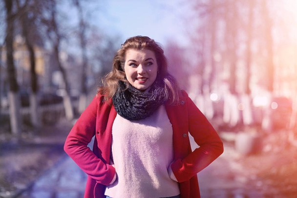 Jolie fille sur une promenade en manteau rouge dans la ville
 - Photo, image