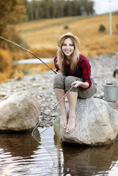 Girl in autumn with a fishing rod - Photo, Image