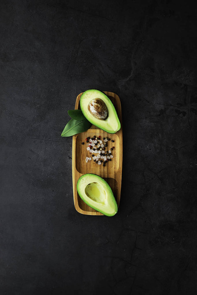 Avocado-Kochrezepte. reife grüne Avocado auf einem Holzschnitt  - Foto, Bild