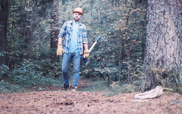 Чоловік лісоруба в лісі. Професійний огляд дереворізів
 - Фото, зображення
