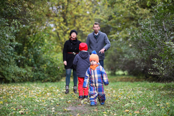 春に公園を散歩する子供を持つ若い家族 - 写真・画像