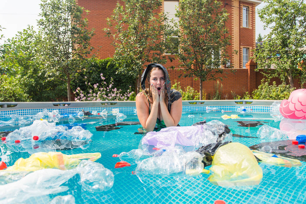 Ökologie, Plastikmüll, Umweltnotstand und Wasserverschmutzung - schreiende Frau mit Plastiktüte über dem Kopf in einem schmutzigen Schwimmbad - Foto, Bild