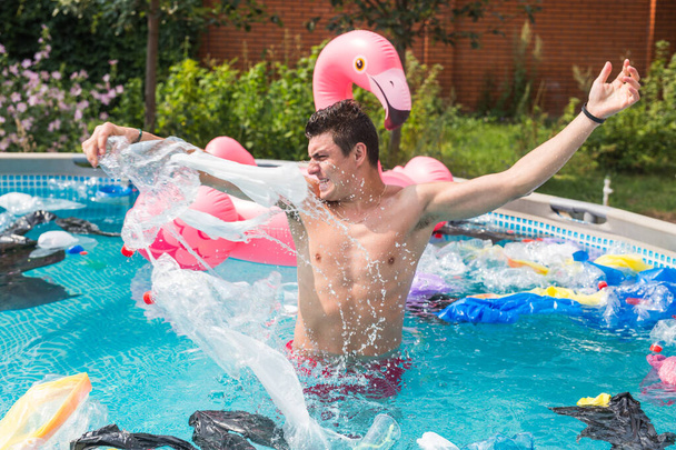 Ecologie, plastic afval, milieuramp en watervervuiling - geschokte man in een vies zwembad - Foto, afbeelding