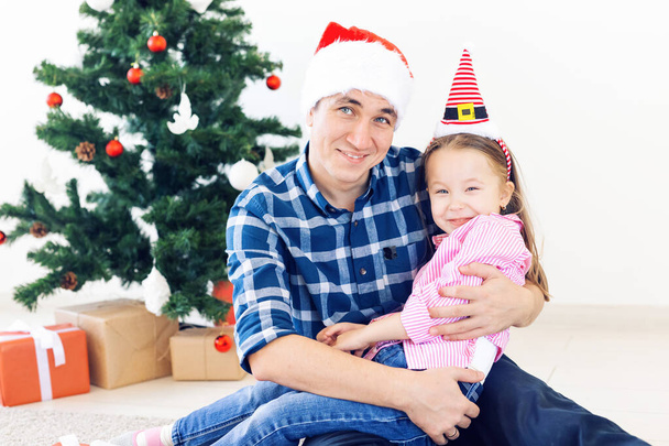 férias, Natal, família e conceito de felicidade - pai engraçado e filha perto da árvore de Natal
 - Foto, Imagem
