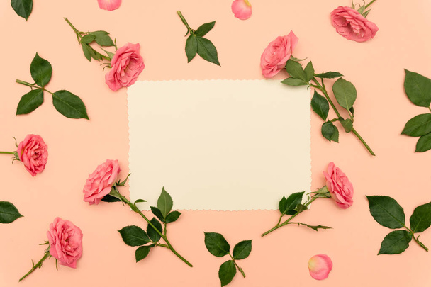 バレンタインデーやその他の休日のコンセプト。柔らかなピンクの背景にバラの花が咲く手紙の写真。結婚式の招待状やヴィンテージスタイルのラブレターのためのモックアップ。コピースペース,平置き - 写真・画像