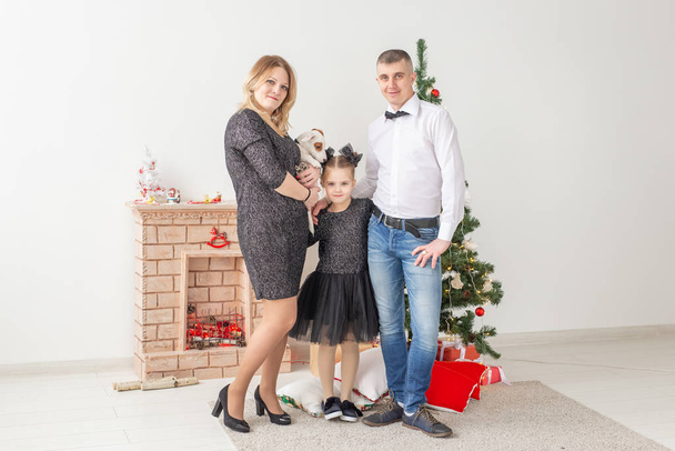 Holidays concept - happy family mother father and child at christmas tree at home - Fotografie, Obrázek
