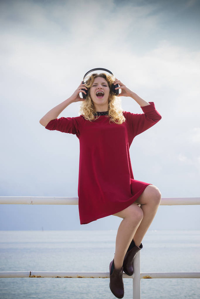 Happy woman wearing headphones outdoor - Fotó, kép