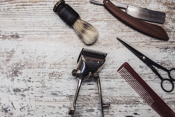 Vintage Friseurwerkzeuge gefährliche Rasierschere alte manuelle Clipper Kamm Rasierpinsel. alten weißen verwitterten Holz Hintergrund. - Foto, Bild