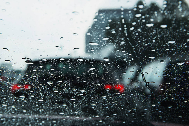 Strada comunale vista attraverso le gocce di pioggia sul parabrezza dell'auto
 . - Foto, immagini