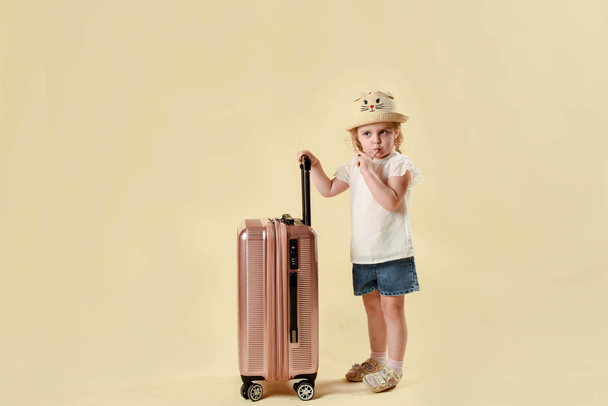 Mother and daughter and baggage. Play in the ladies. trip to the sea. rest and vacation in the summer. Travel concept. on a light background in the studio - Foto, Imagen