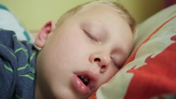 Portret. Chłopak śpi z otwartymi ustami. Nos dziecka nieoddychającego w wyniku przeziębienia. - Materiał filmowy, wideo