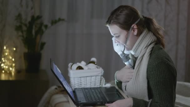 Kranke Frau, die unter Halsschmerzen leidet, wird mit Medikamenten behandelt, die den richtigen Inhalator verwenden, um Erkältungen oder Grippe zu behandeln, während sie im Zimmer auf der Couch sitzt - Filmmaterial, Video