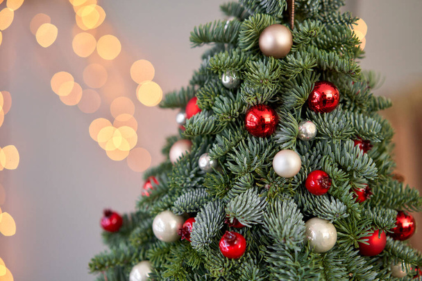 Krásný malý vánoční stromek na dřevěném stole. Šťastná nálada. Garland lampa bokeh na pozadí. Tapeta. Dánská borovice a jedle, Nobilis - Fotografie, Obrázek