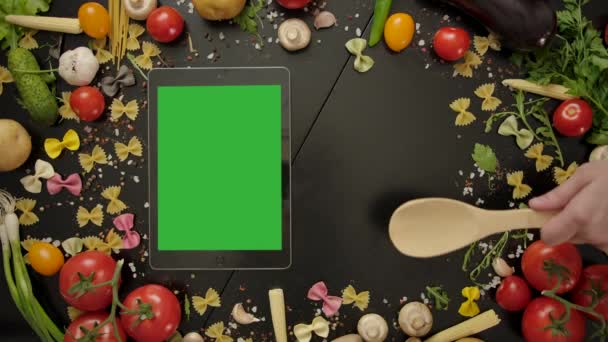 Aşçı tahta kaşıkla el sallıyor yeşil ekran tabletlerine bakıyor. - Video, Çekim