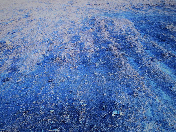 gros plan de la surface de la terre avec un effet bokeh et une texture poreuse rugueuse caractéristique, des taches sombres et claires abstraites sur un fond bleu classique
 - Photo, image