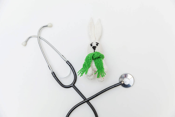 Просто минимальный дизайн игрушки кролика и медицинского оборудования стетоскоп изолированы на белом фоне. Здравоохранение детский врач концепция. Символ педиатра. Плоская ложа, пространство для копирования сверху
 - Фото, изображение