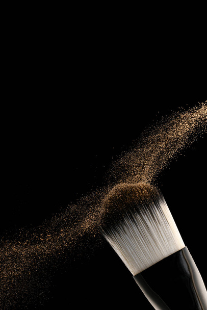 Flat blush brush on black background scatters blush around - Foto, Imagen