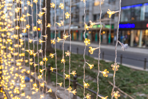Різдвяні електричні гірлянди, що звисають на вулиці
 - Фото, зображення
