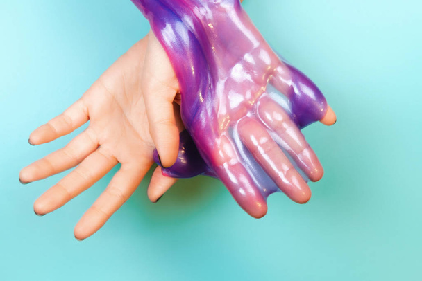 hands with holding slime in purple color - Fotoğraf, Görsel