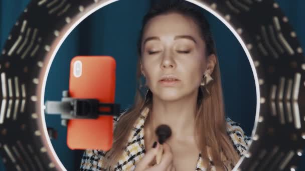 View of pretty woman beauty blogger does contouring in front of ring light. - Footage, Video
